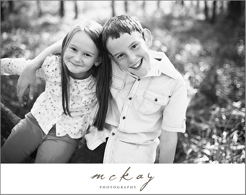 black & white photo kids on a log