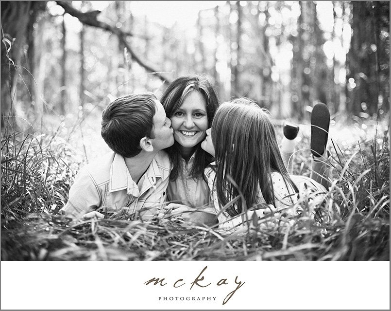 two children kissing their mum
