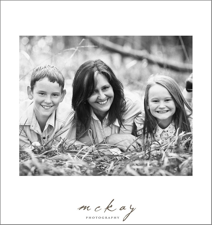 mum with kids kissing cheek black white photo