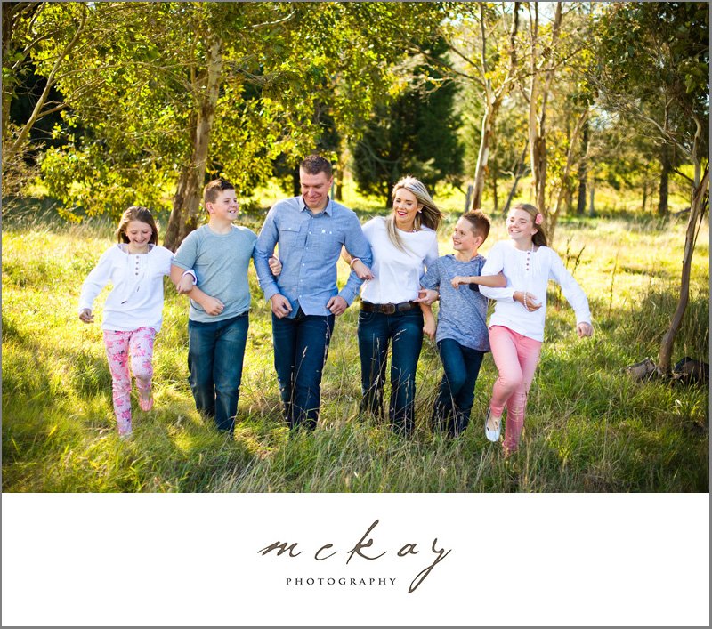 family photo in long grass linking arms